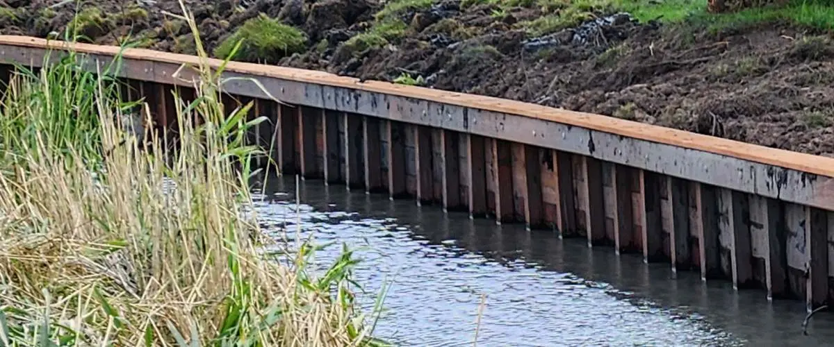 Walbeschoeiing van hardhout laten plaatsen – Dijkstra Waterbouw